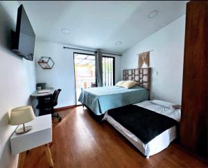 une chambre avec un lit et un bureau et un lit sidx sidx sidx dans l'établissement Posada Botero, à San Andrés