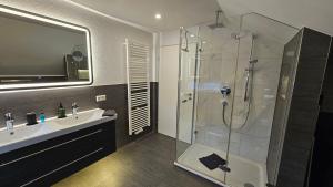a bathroom with a glass shower and a sink at MF Manuele Ficano - Ferienwohnungen am Bodensee - Fewo Luna in Kressbronn am Bodensee +17 photos