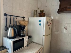 a kitchen with a white refrigerator and a microwave at Dar Meftah Tanger in Tangier