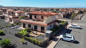 an aerial view of a house with cars parked in a parking lot at Villa Maracuya in Lajares