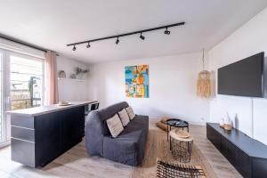 a living room with a couch and a flat screen tv at Appartement Proche Disney Paris Vidéo-Projecteur in Bussy-Saint-Georges