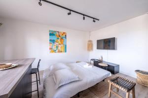 a white bedroom with a bed and a desk at Appartement Proche Disney Paris Vidéo-Projecteur in Bussy-Saint-Georges +10 photos
