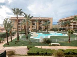 a resort with a swimming pool and palm trees at Apartamento Marmara in Jávea