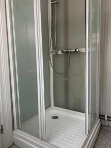 a shower with a glass door in a bathroom at Tørresvangen in Tynset