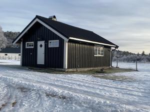 a black building with a white door in the snow at Tørresvangen in Tynset +6 photos