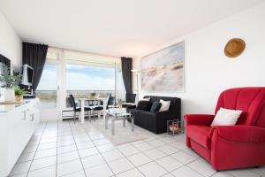 a living room with a red couch and a table at TimmenKoje App 290 in Timmendorfer Strand