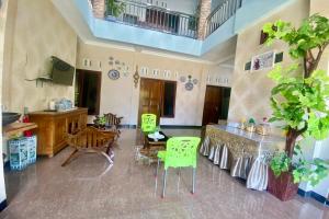 a living room with green chairs and a table at Griya Berkah Syariah in Kutoarjo