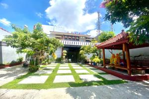 a courtyard of a building with grass and trees at Griya Berkah Syariah in Kutoarjo