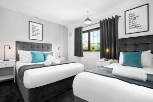 two beds in a bedroom with blue and white at Three Bedroom House - Garden Space - Parking Included - Netflix Access - Parking - 74B in Walsall Wood +50 photos