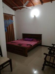 a bedroom with a bed and a chair in it at Villa 133 - 2 bed rooms in Dodanduwa