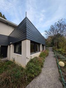 a house with a black roof and a pathway at B&B Le Gorget in La Tronche
