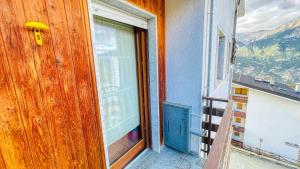 a door to a balcony with a view of a mountain at Appartamento Lo Scoiattolo - Affitti Brevi Italia in Sauze dʼOulx +9 photos