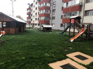 a playground with a slide in a yard next to a building at Apartament de lux cu 3 camere in Bacău