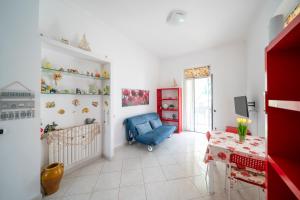 a living room with a blue chair and a table at Villa Verde - 300m From Sea in Bordighera