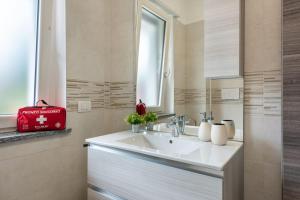 a bathroom with a white sink and a red bag at La casa di Adelina vicino MXP e Rho fiera in Busto Arsizio