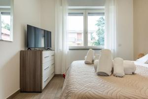 a bedroom with a television and a bed with pillows at La casa di Adelina vicino MXP e Rho fiera in Busto Arsizio