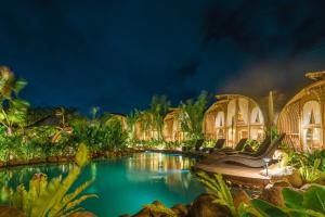 a resort with a swimming pool at night at Curve Villas Boutique Resort in Tanah Lot
