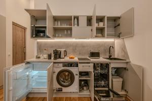 a kitchen with a washer and dryer under a counter at Railway Apartments in Vilnius