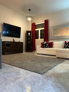 a living room with a couch and a flat screen tv at Basement apartments in San Bartolomé de Tirajana