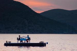 zwei Menschen sitzen an einem Tisch mitten in einem See in der Unterkunft Sabrinas Haus - Adult Only +14 in Bozburun