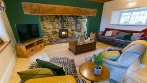 a living room with a couch and a fireplace at Tal y Bont Barns in Bangor