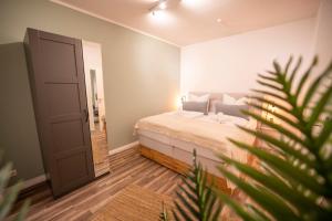 a bedroom with a bed and a plant at RR - Spacious Apartments - Central - Parking in Magdeburg