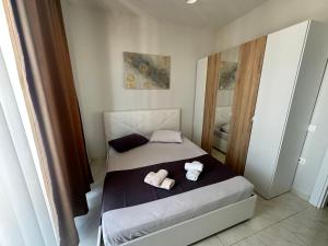 a bedroom with a bed with two towels on it at Luxury Apartment with Parking in Tirana