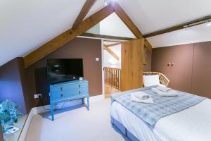 a bedroom with a bed and a tv in a room at Tal y Bont Barns in Bangor