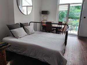 a bedroom with a bed with a table and a mirror at Le Liégeois - proche centre - Maison de maître in Liège