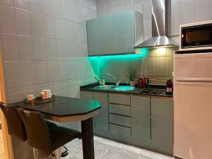 a kitchen with a table and a sink and a refrigerator at Basement apartments in San Bartolomé