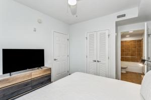 Un dormitorio blanco con una cama y un televisor de pantalla plana. en Beach Club 2B - 201A by Premier Island Management Group, en Pensacola Beach 22 fotos más