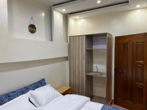 a small bedroom with a bed and a cabinet at Live Well Rwanda House in Kigali