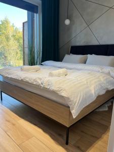 a large bed in a bedroom with a large window at Laguna Beskidów Apartament A5 in Zarzecze