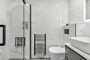 a bathroom with a shower and a toilet and a sink at Chic 3-Bed Townhouse,2 Mins to Windsor's Long Walk in Windsor +10 photos