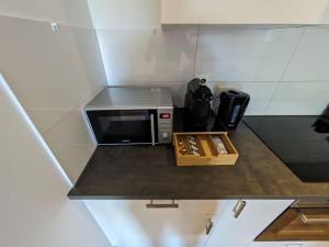 a microwave sitting on a counter in a kitchen at Apartment 'Weiden' Grenze Enschede in Gronau