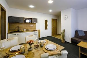 a kitchen and living room with a table and chairs at Villa Michaela in Bešeňová