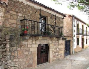 een stenen gebouw met een balkon en een deur bij Las Frascuelas in Almajano