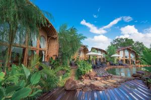 a resort with a pool and trees and buildings at Curve Villas Boutique Resort in Tanah Lot