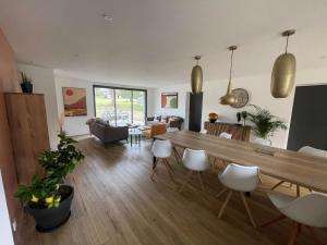 ein Wohnzimmer mit einem großen Holztisch und Stühlen in der Unterkunft Chambres d'hôtes ''La Clairière aux Chênes'' in Treillières