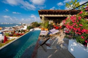 a balcony with a table and chairs and flowers at Casa Pancha Puerto Vallarta Centro - Adults Only in Puerto Vallarta