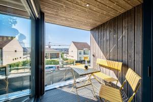 a patio with a table and chairs on a balcony at L'Escapade - PARIS 20 min - DISNEY 25 min - GARE 3 min à pied - PARKING - Confortable & Moderne - Free WIFI in Pomponne