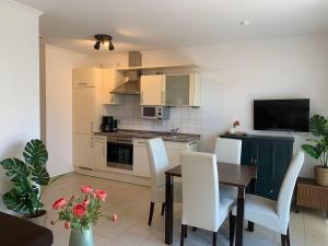 a kitchen and dining room with a table and chairs at Haus-am-See-Kolkstr-1-EG-rechts in Norddeich +6 photos