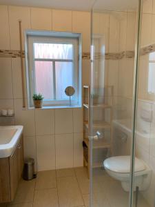 a bathroom with a toilet and a sink and a window at Haus-am-See-Kolkstr-1-EG-rechts in Norddeich