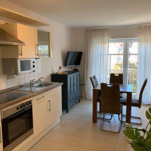 a kitchen with a table and a dining room at Haus-am-See-Kolkstr-1-OG-rechts in Norddeich