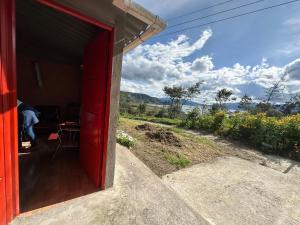 a red door of a red house with a view at Vista al Lago, Cabaña Privada in Pasto +2 photos