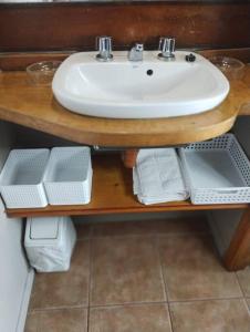 a bathroom sink on a wooden table with towels at Departamento Céntrico San Martin de los Andes in San Martín de los Andes