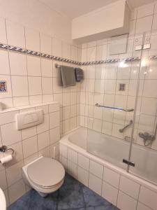 a bathroom with a toilet and a tub and a sink at Zur Turmstube in Dossenheim