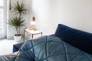 Un sofá azul en una sala de estar con plantas. en Dreams Little Apartment - M5 Station - Near Center, en Milán