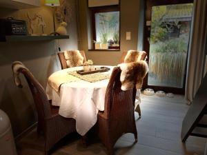 a dining room with a table with two chairs and a tableablish at Le Brâme du Cerf in Theux