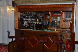 a bar with stools in front of a counter at City Inn in St. Davids